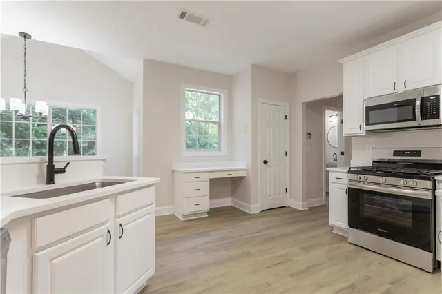a kitchen with a sink cabinets and stainless steel appliances