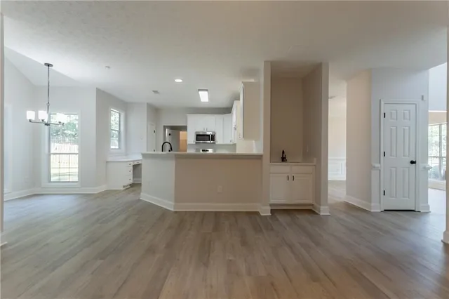 a view of a kitchen with wooden floor and windows