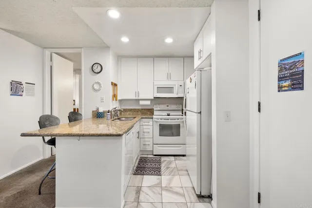 a kitchen with a sink a stove a refrigerator and cabinets