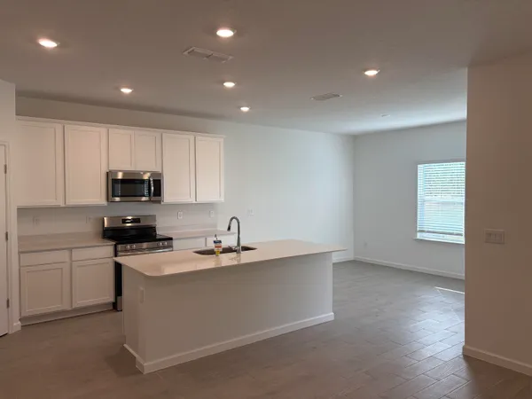 a kitchen with kitchen island granite countertop a sink stainless steel appliances and white cabinets