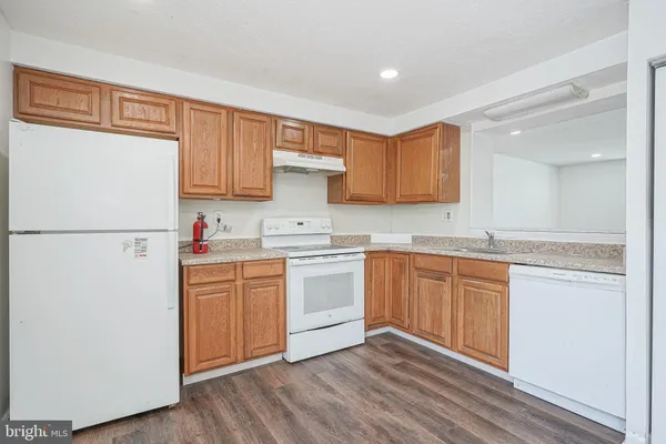 a kitchen with granite countertop white cabinets and white appliances