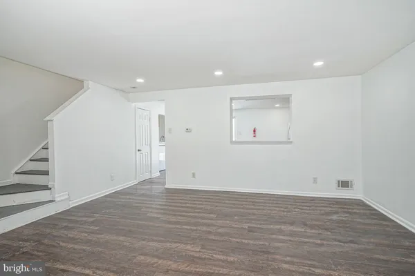 an empty room with wooden floor and white walls