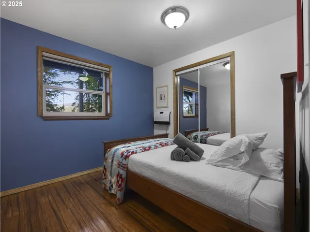 a bedroom with a bed and wooden floor