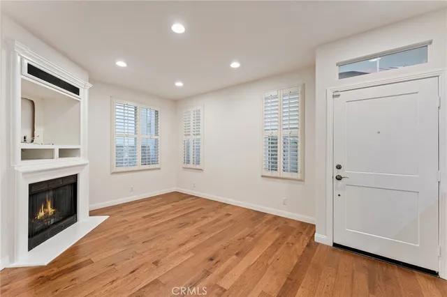 a view of empty room with wooden floor and fireplace