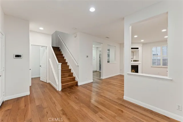 an empty room with wooden floor and entryway
