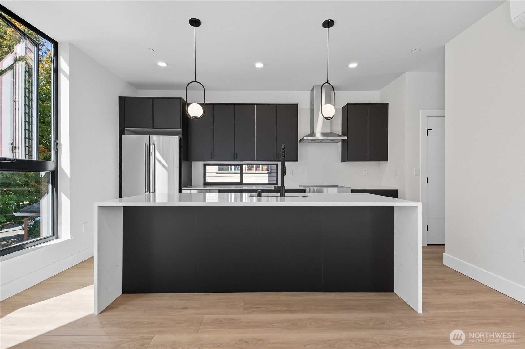 218 21st Avenue East Seattle, WA 98112 - Photo 8 of 38 a kitchen with kitchen island a refrigerator a sink and wooden floor