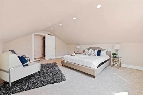 a spacious bedroom with a bed and wooden floor