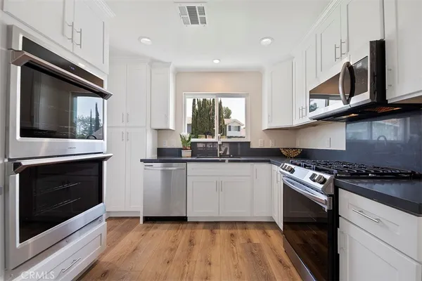 a kitchen with stainless steel appliances granite countertop a stove microwave and sink