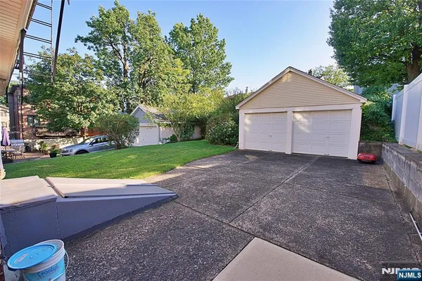 a view of a house with a yard and a large tree