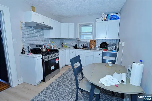 a kitchen with a stove a sink cabinets and a dining table