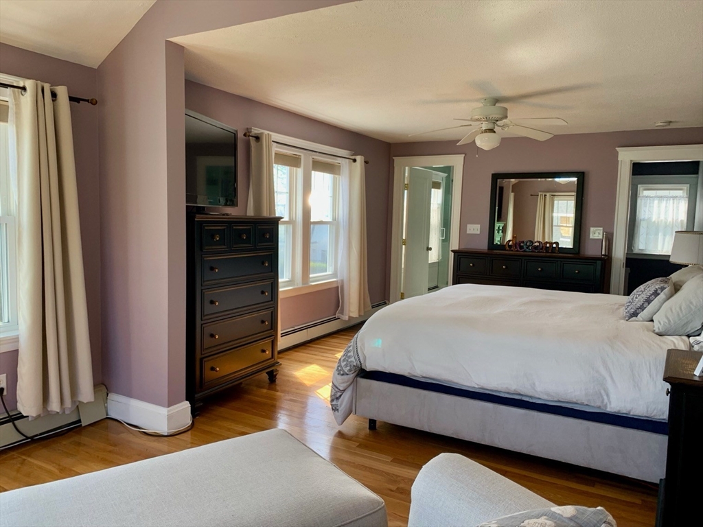 15 Maypole Road Quincy, MA 02169 - Photo 25 of 28 a bedroom with a bed windows and a chandelier