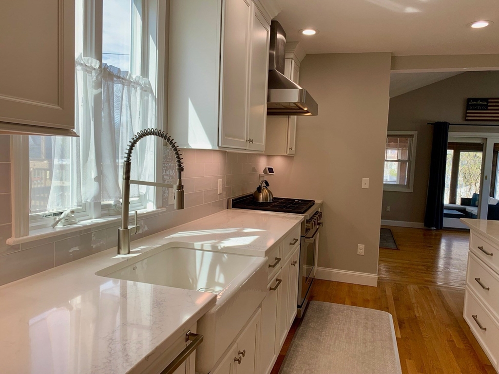 15 Maypole Road Quincy, MA 02169 - Photo 8 of 28 a kitchen with stainless steel appliances granite countertop a sink a stove and a wooden floors