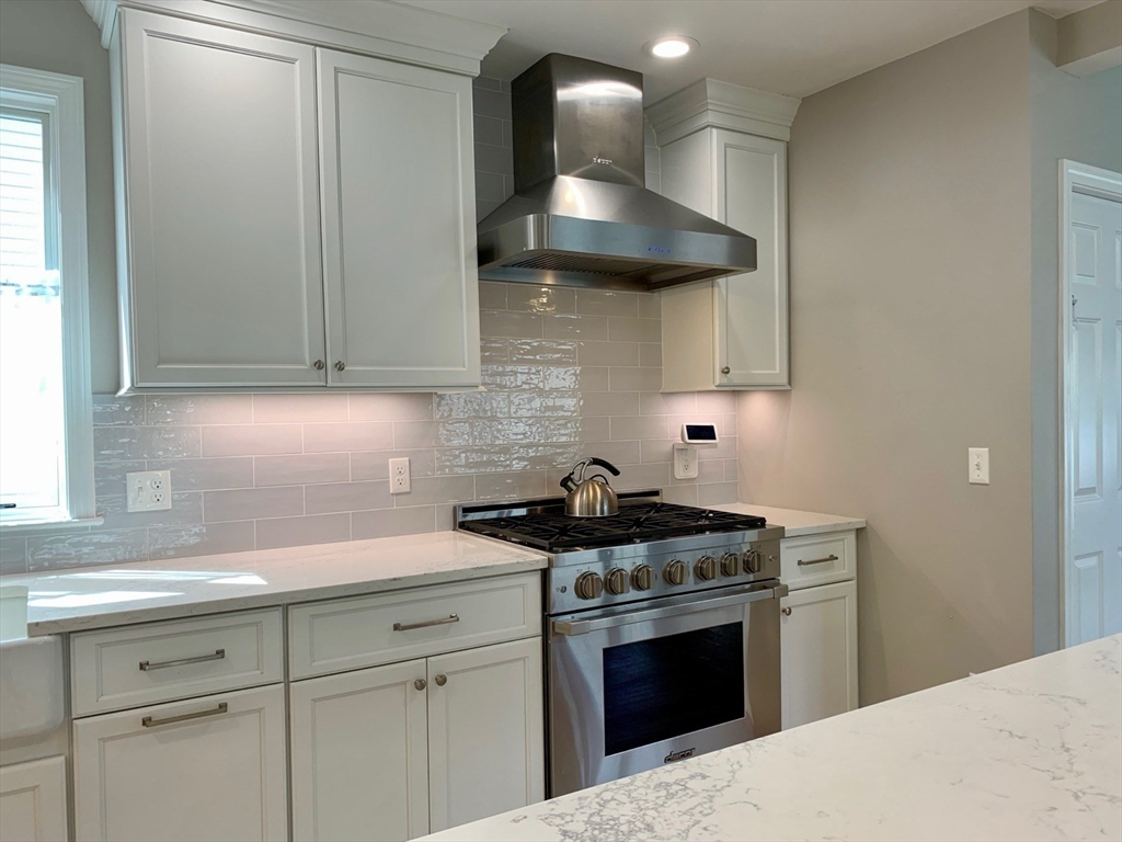 15 Maypole Road Quincy, MA 02169 - Photo 9 of 28 a kitchen with stainless steel appliances granite countertop a sink stove and cabinets