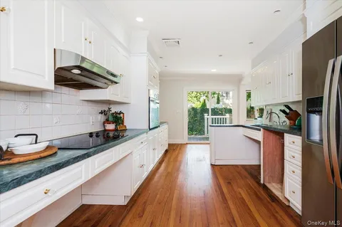 a kitchen with stainless steel appliances a sink a wooden floor and cabinets