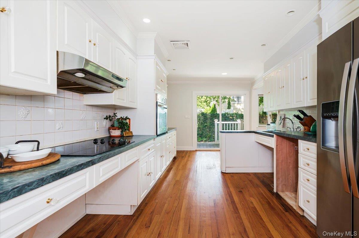 237 Oakwood Road Huntington, NY 11743 - Photo 12 of 29 a kitchen with stainless steel appliances a sink a wooden floor and cabinets