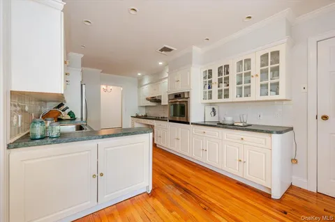 a kitchen with granite countertop white cabinets and white appliances