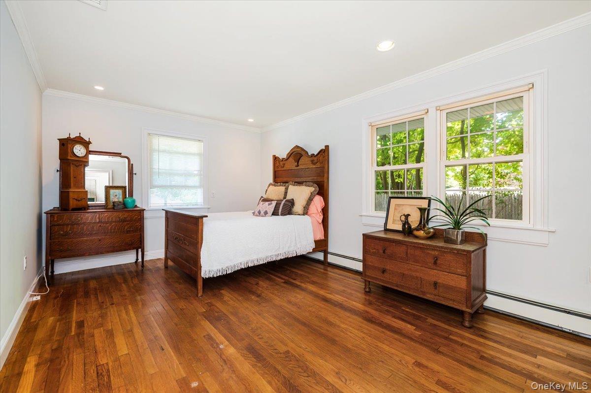 237 Oakwood Road Huntington, NY 11743 - Photo 15 of 29 a bedroom with a bed and wooden floor