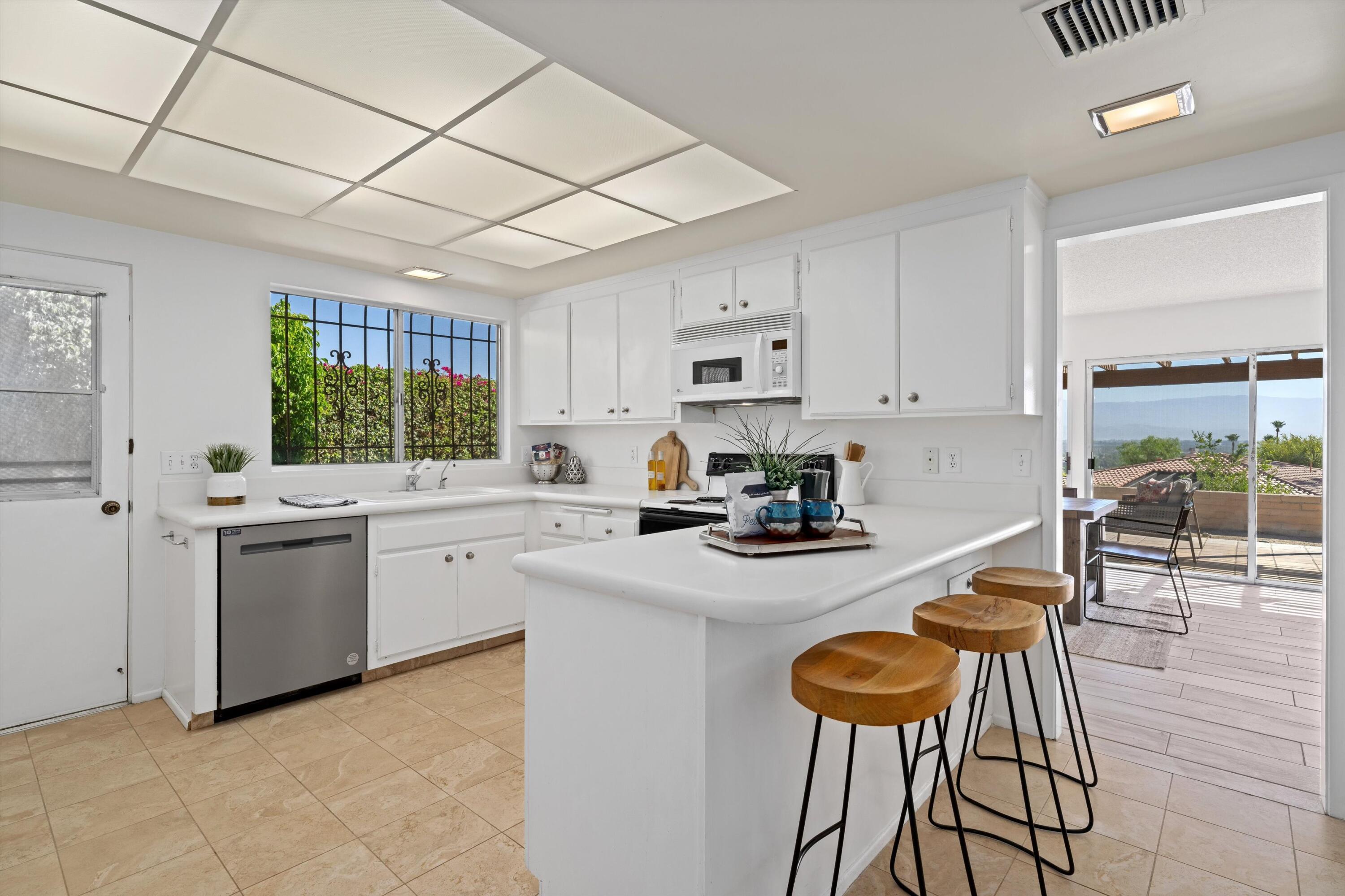 40270 Paseo Del Rey Rancho Mirage, CA 92270 - Photo 18 of 41 a kitchen with sink a stove and chairs