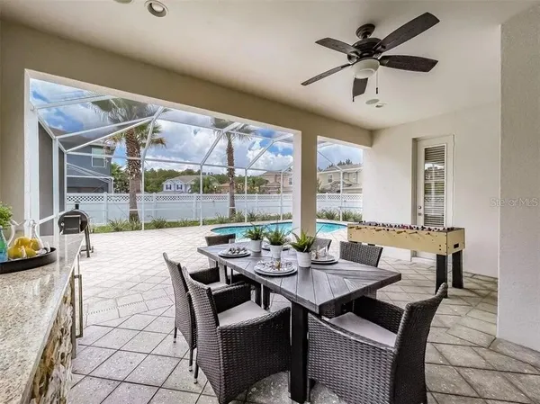 a view of swimming pool with a lounge chair and palm trees