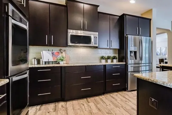 a kitchen with granite countertop cabinets stainless steel appliances and potted plant