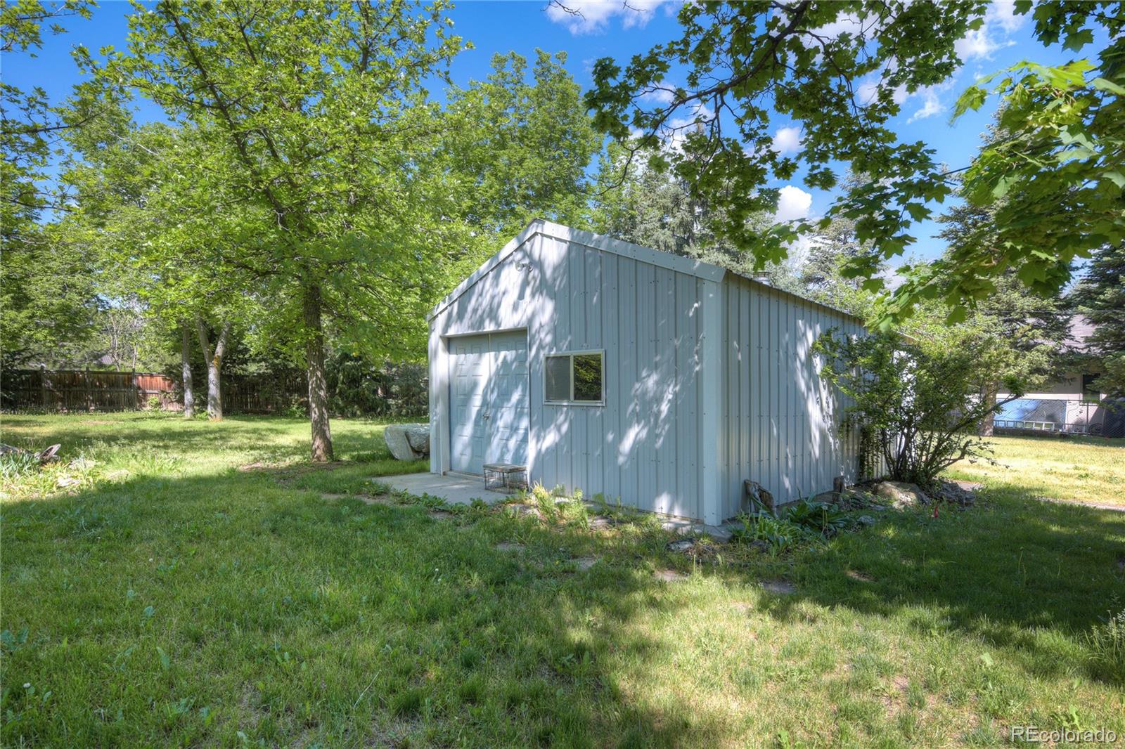 4405 Agate Road Boulder, CO 80304 - Photo 38 of 40 a backyard of a house with plants and large trees