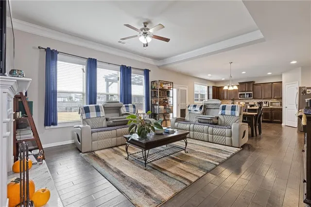 a living room with furniture kitchen view and a large window