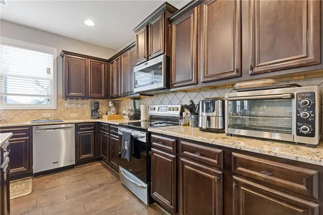 a kitchen with stainless steel appliances granite countertop a sink stove and microwave