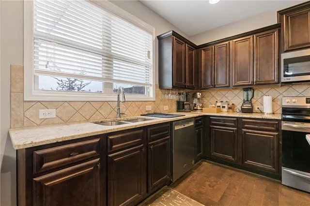 a kitchen with stainless steel appliances granite countertop a sink stove and cabinets