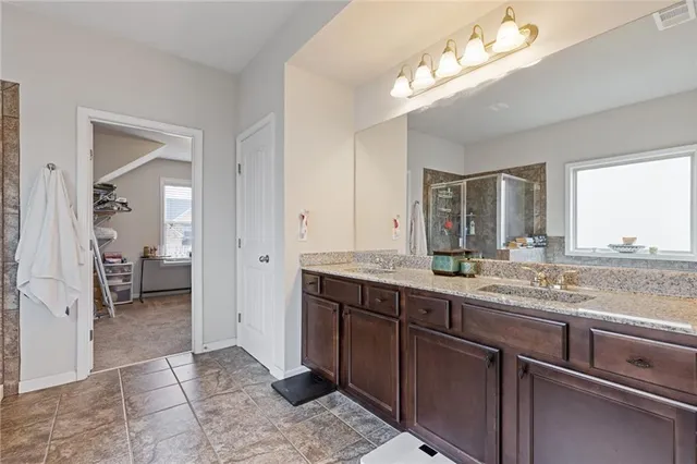 a spacious bathroom with a granite countertop sink and a mirror