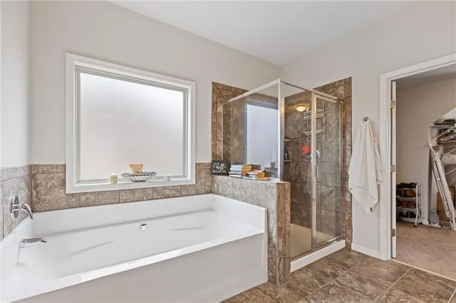 a bathroom with a bathtub a shower a sink and a mirror