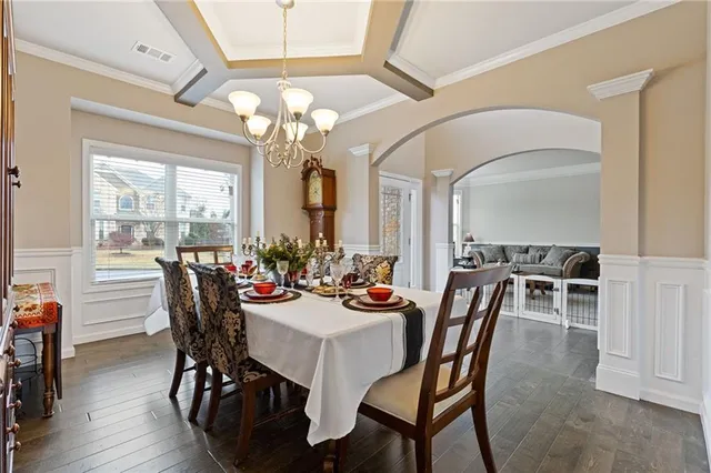 a view of a dining room with furniture a chandelier and wooden floor