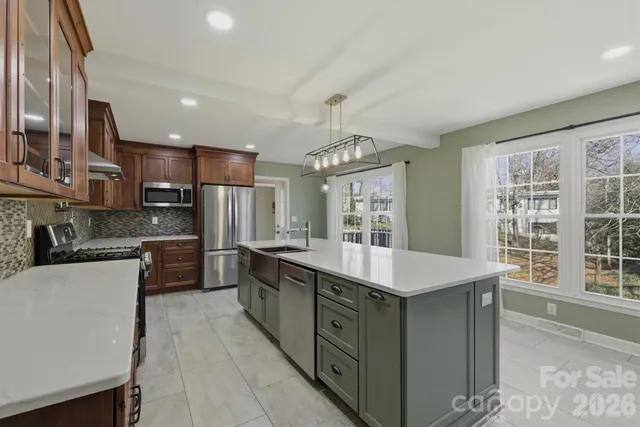 a kitchen with stainless steel appliances granite countertop a sink counter space cabinets and a large window