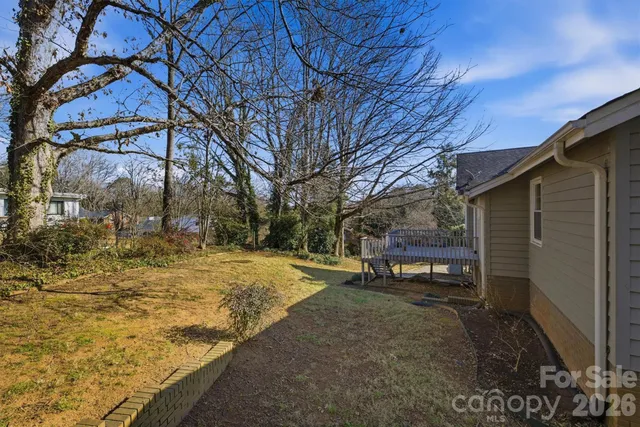 a view of a backyard with table and chairs and a large tree