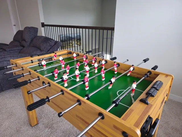 a room with pool table wooden floor and stairs