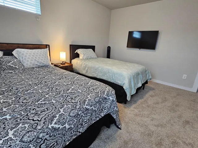 a bedroom with two beds and a flat screen tv