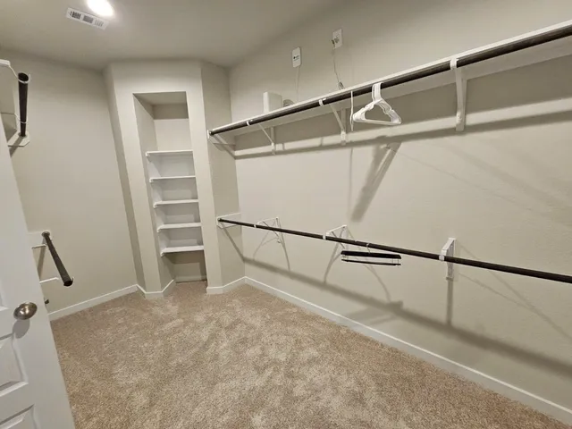 a view of walk in closet with empty racks