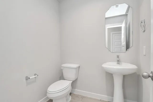a bathroom with a sink toilet and a mirror