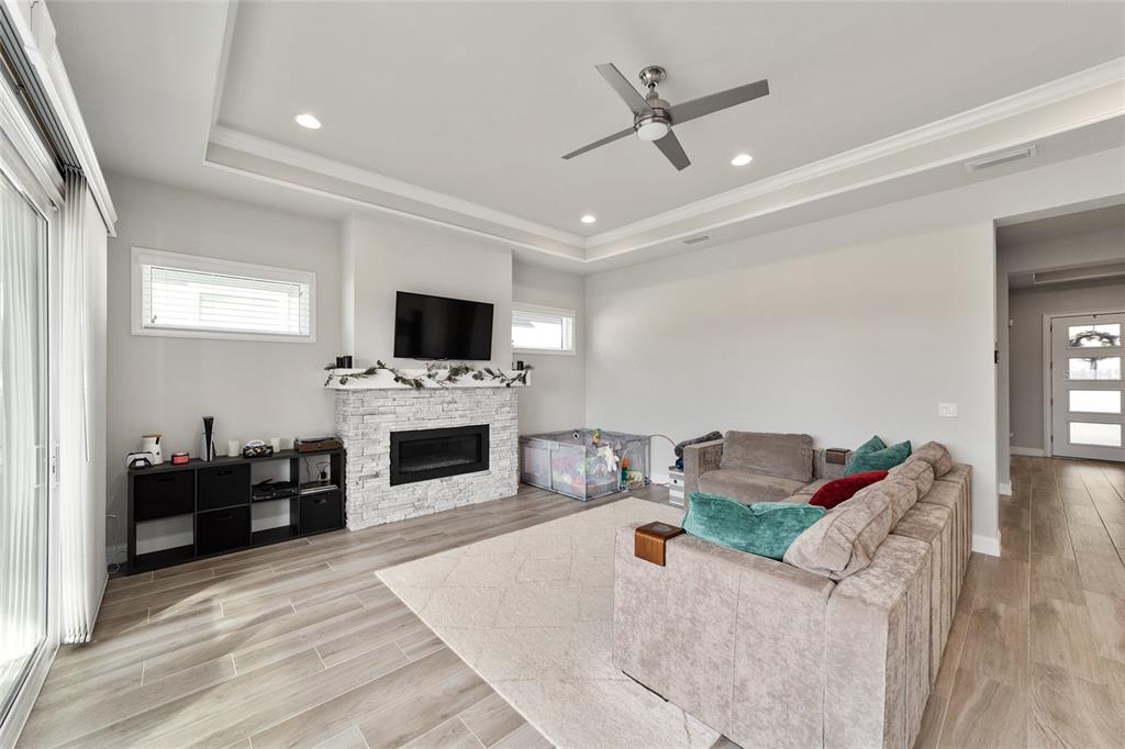 11895 Southwest 33 Lane Gainesville, FL 32608 - Photo 18 of 67 a living room with furniture a fireplace and a flat screen tv