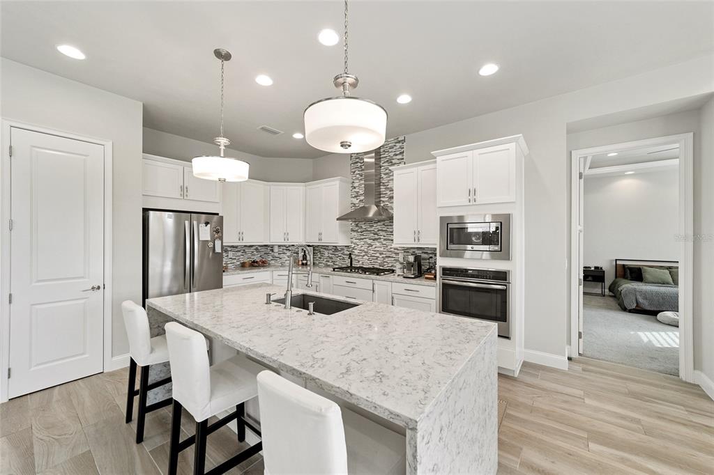 11895 Southwest 33 Lane Gainesville, FL 32608 - Photo 27 of 67 a kitchen with stainless steel appliances granite countertop a sink a stove a refrigerator and island with wooden floor