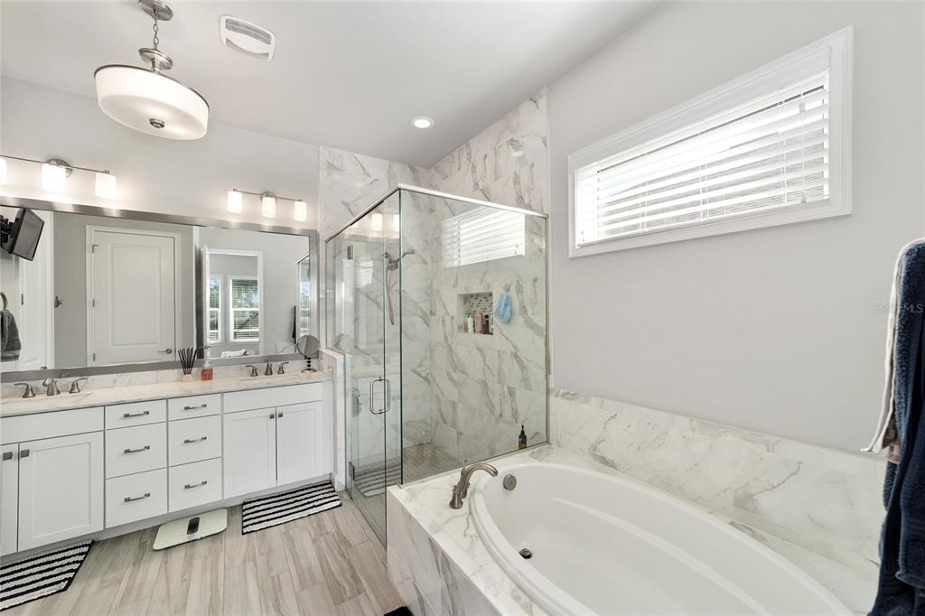 11895 Southwest 33 Lane Gainesville, FL 32608 - Photo 36 of 67 a bathroom with a bathtub a sink and a large mirror