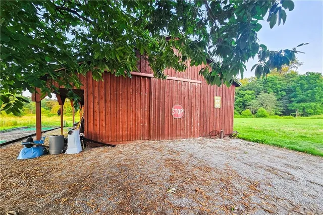 a view of a backyard with large trees and wooden fence