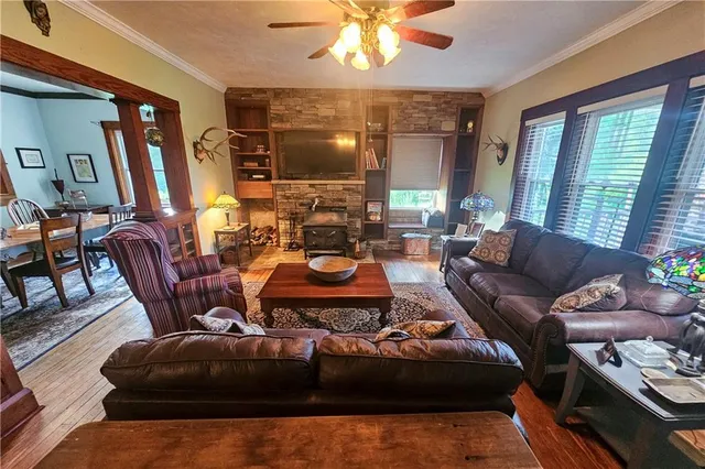a living room with furniture a large window and a chandelier