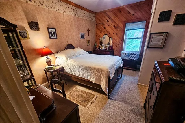 a bedroom with a bed and a flat tv screen on the dresser