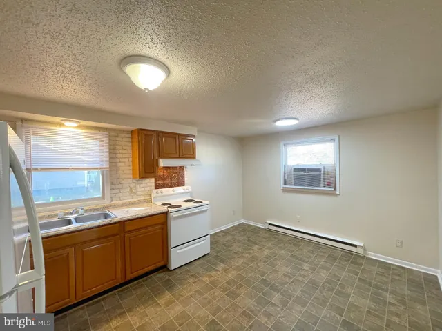 a large kitchen with a stove a sink dishwasher and a refrigerator