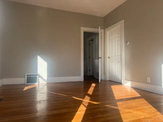 a view of a room with wooden floor and glass doors