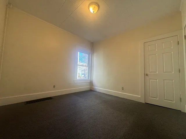 an empty room with a window and a fireplace