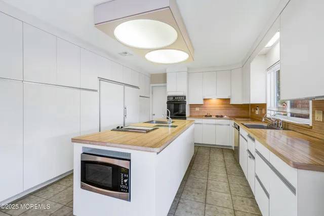 a kitchen with a stove sink and cabinets