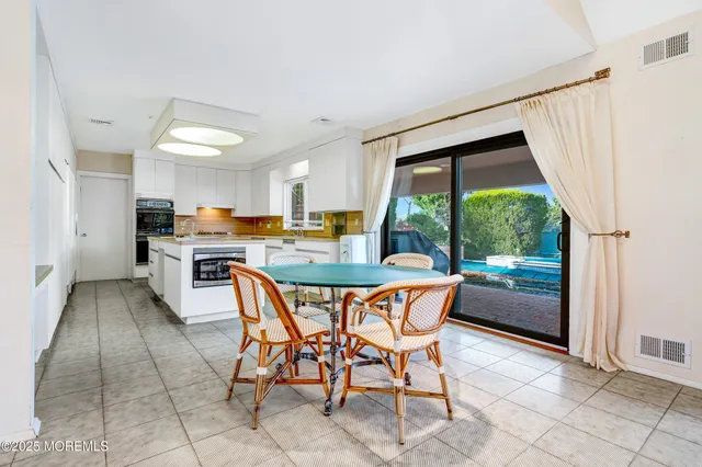a dining area with stainless steel appliances a sink a counter top space and a view of kitchen