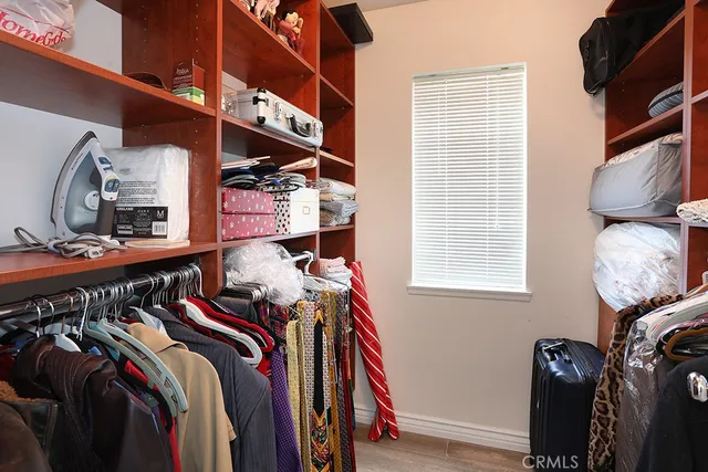 a view of walk in closet with clothes and shoes