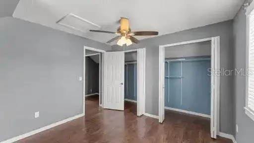 a view of a room with wooden floor and ceiling fan